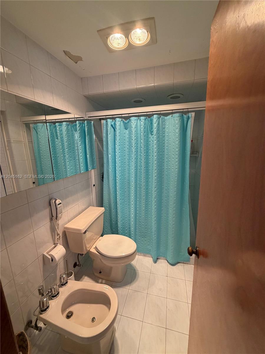3262 Southwest 139th Place Miami, FL 33175 - Photo 22 of 36 a bathroom with a toilet a sink and a shower curtain