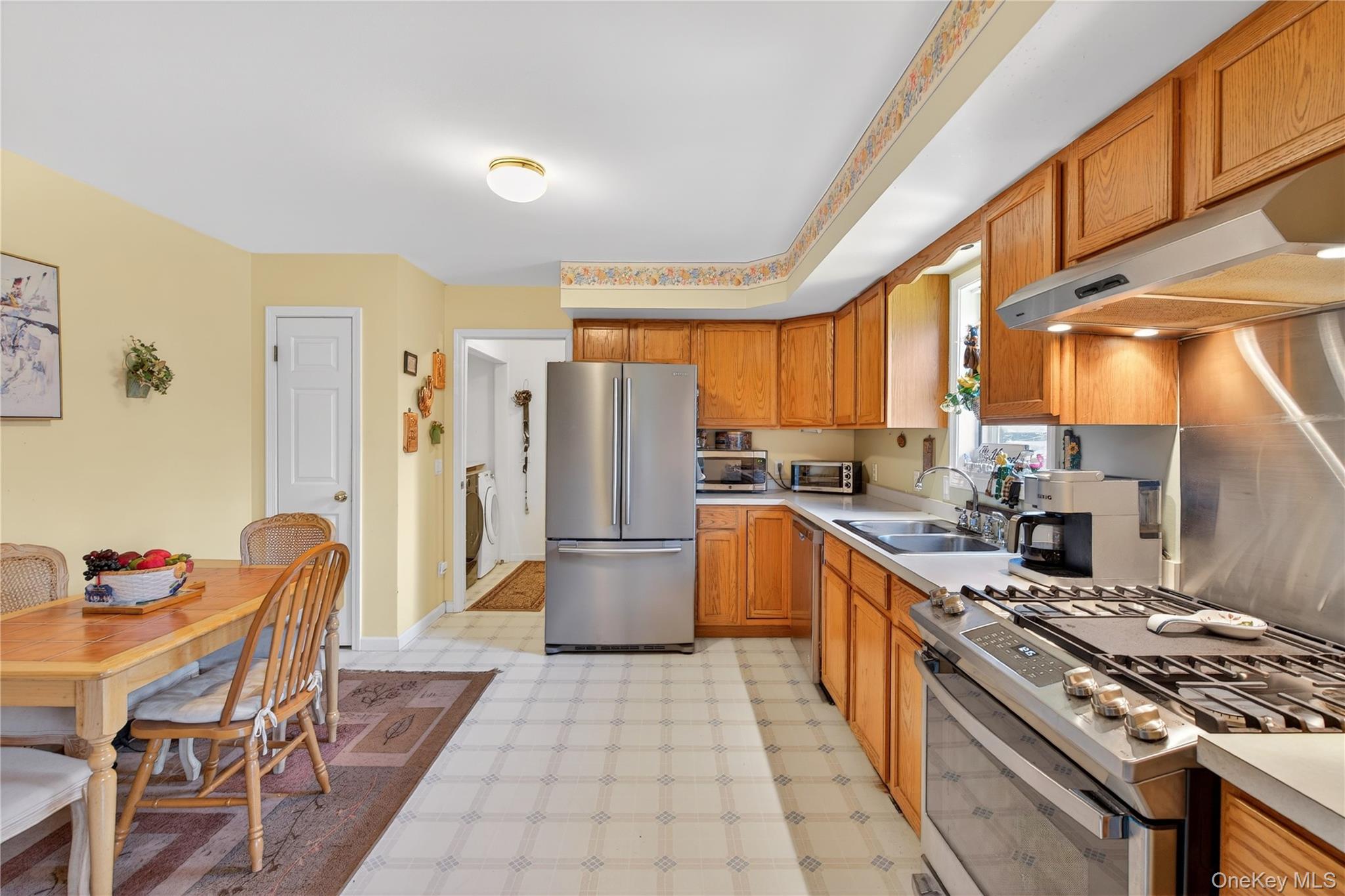 1044 Blue Mountain Road Saugerties, NY 12477 - Photo 10 of 32 a kitchen with stainless steel appliances granite countertop a stove a refrigerator a sink a dining table and chairs with the wooden floor