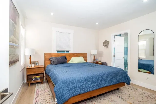 a bedroom with a bed and wooden floor