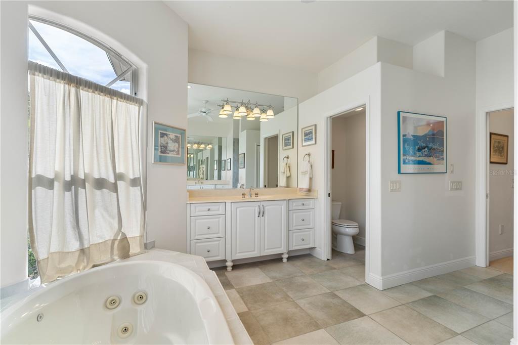 2736 Mayaguana Court Punta Gorda, FL 33950 - Photo 40 of 80 a spacious bathroom with a double vanity sink a mirror a bathtub and shower