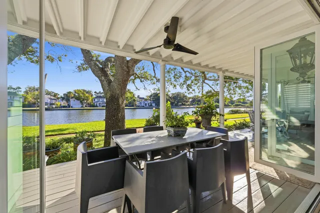 a view of a dining room with furniture large windows and a chandelier