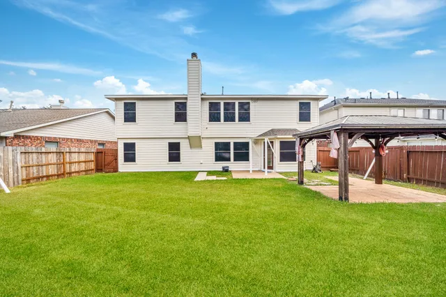 a view of a house with a backyard
