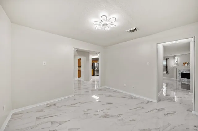 a view of empty room with wooden floor and fireplace