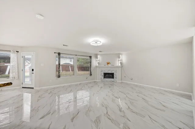 an empty room with a window and wooden floor