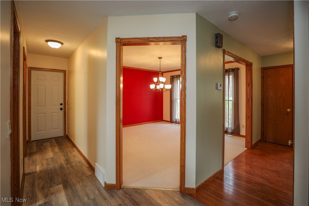12565 Alpha Road Hiram, OH 44234 - Photo 18 of 50 Corridor with baseboards, a notable chandelier, and wood finished floors