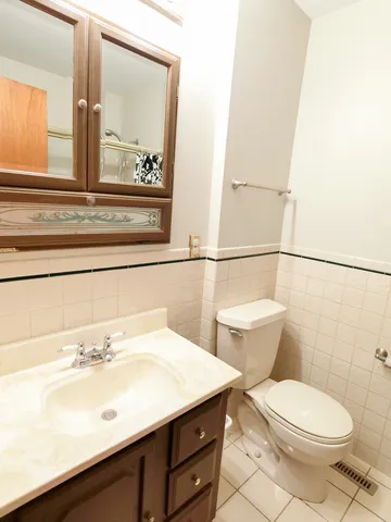a bathroom with a sink a toilet and mirror