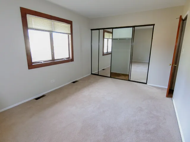 an empty room with windows and closet