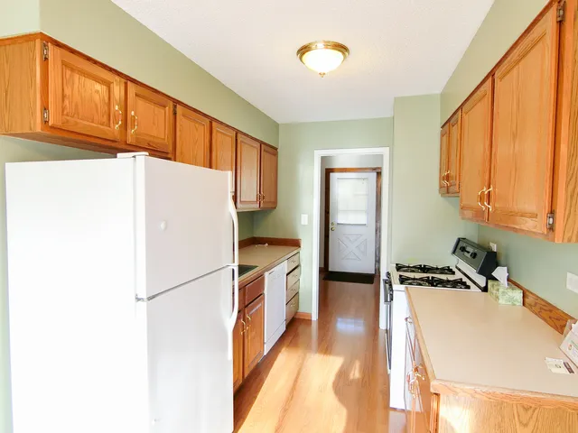 a kitchen with a refrigerator a stove top oven and cabinets