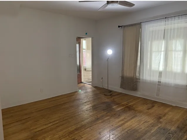 a view of an empty room with wooden floor