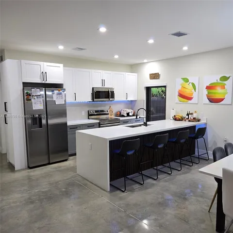 a kitchen with refrigerator cabinets and dining table