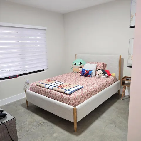 a bed sitting in a bedroom next to a window