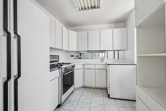 a kitchen with granite countertop white cabinets and white appliances
