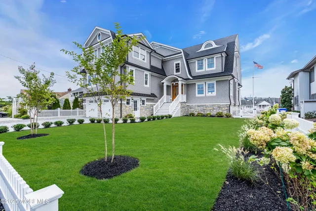 a view of a house with a big yard potted plants and large tree