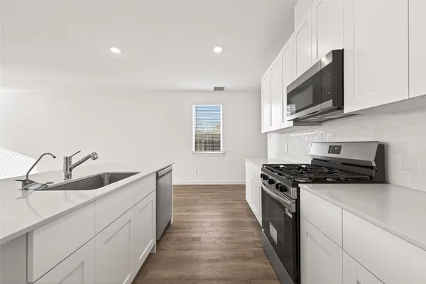 a kitchen with stainless steel appliances granite countertop a sink and a stove