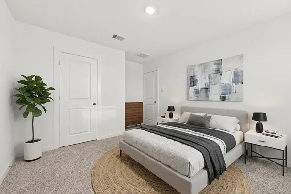 a bedroom with a bed and a potted plant