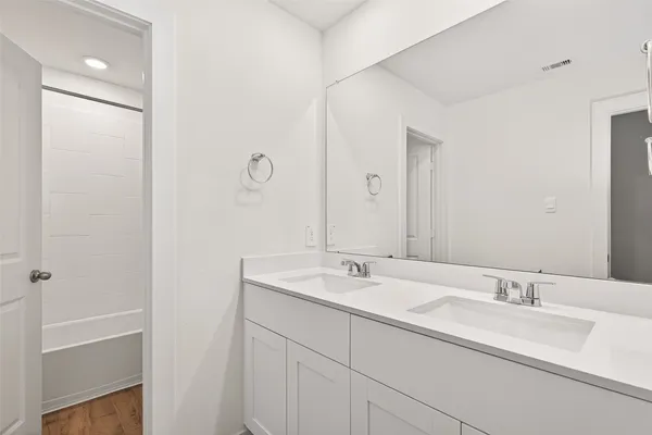 a bathroom with a double vanity sink and a mirror