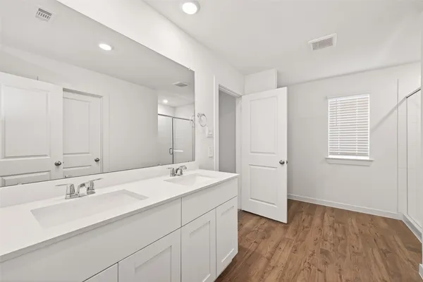 a bathroom with a sink double vanity granite tub and a mirror