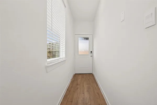 a view of a room with wooden floor and a window