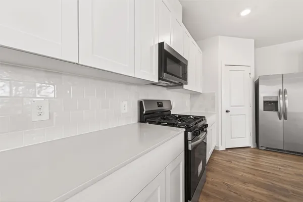 a kitchen with stainless steel appliances white cabinets and a stove