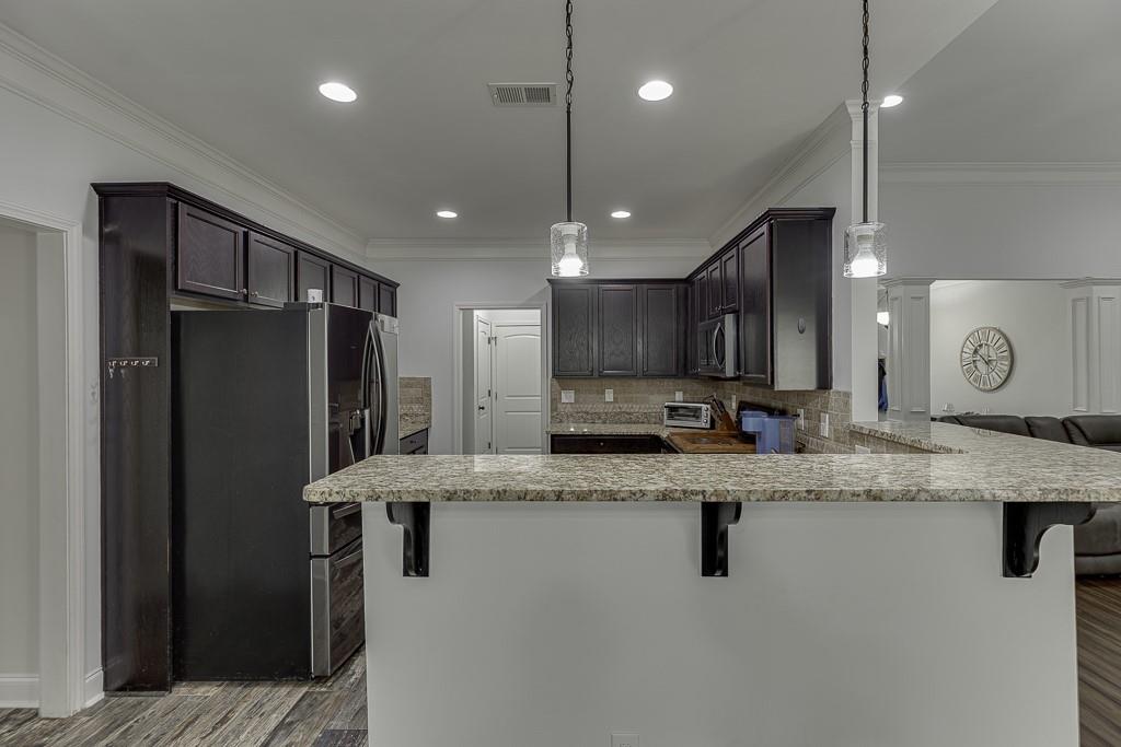 2858 Shadowstone Way Winder, GA 30680 - Photo 17 of 52 a kitchen with stainless steel appliances granite countertop a refrigerator a sink a stove a microwave and island