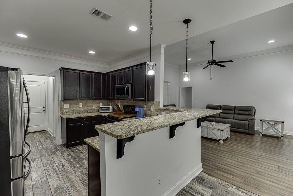 2858 Shadowstone Way Winder, GA 30680 - Photo 18 of 52 a kitchen with stainless steel appliances granite countertop a sink a stove and a refrigerator