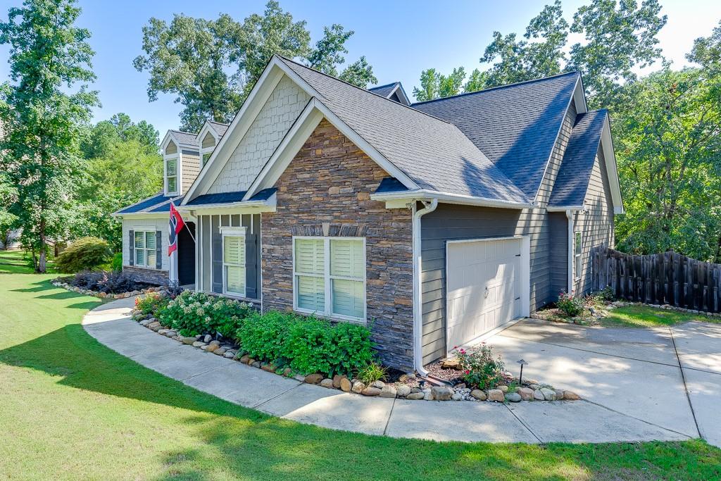 2858 Shadowstone Way Winder, GA 30680 - Photo 2 of 52 a view of a brick house with a yard plants and a large tree