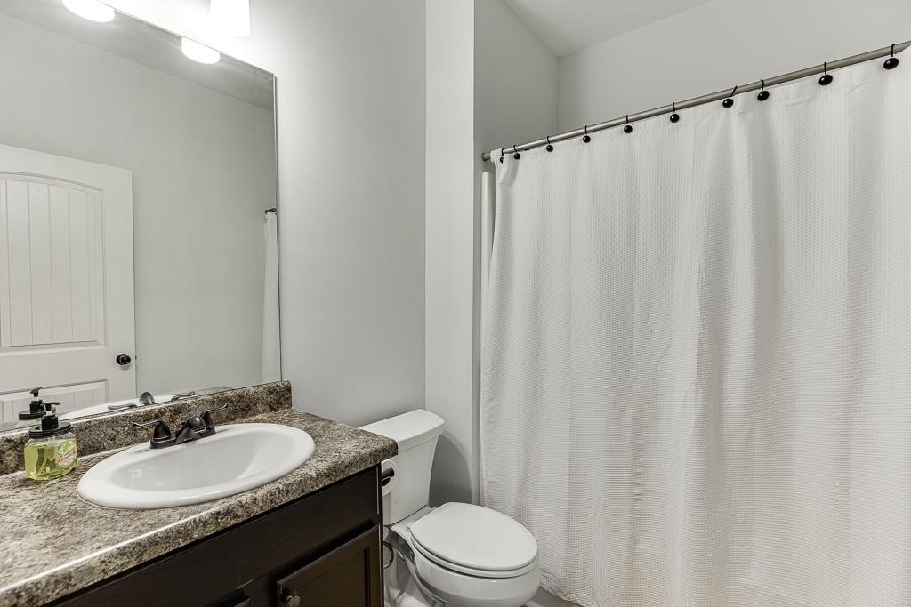 2858 Shadowstone Way Winder, GA 30680 - Photo 31 of 52 a bathroom with a granite countertop sink toilet and a mirror