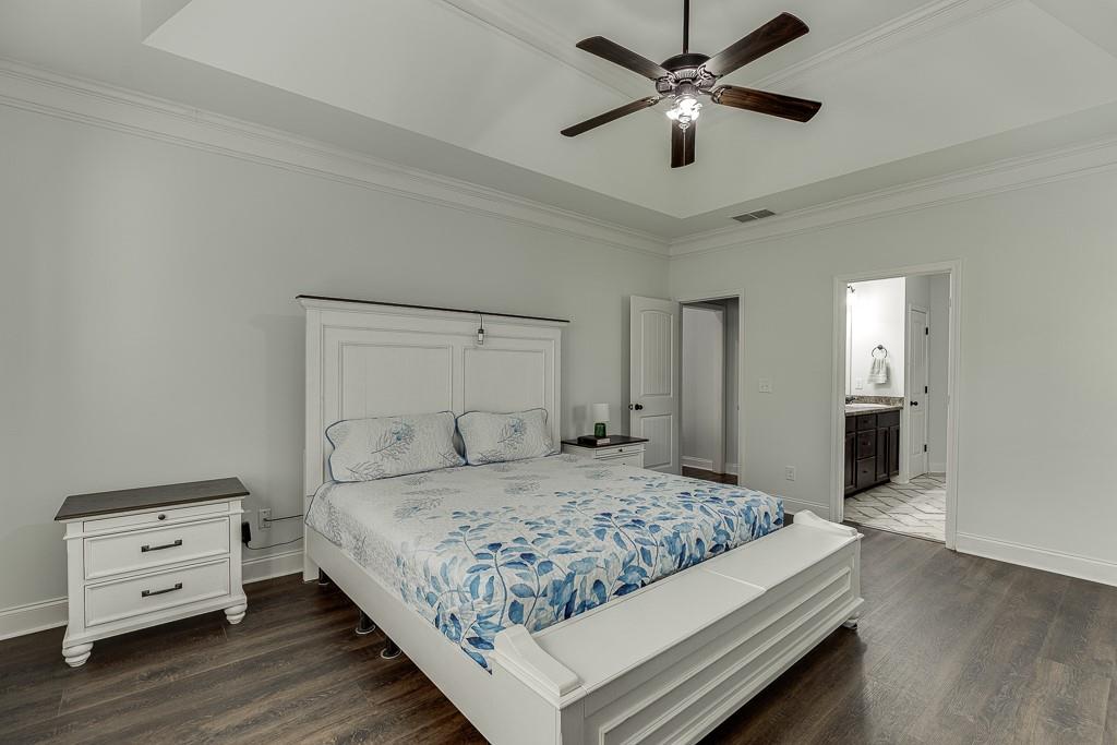 2858 Shadowstone Way Winder, GA 30680 - Photo 34 of 52 a bedroom with a bed and a chandelier