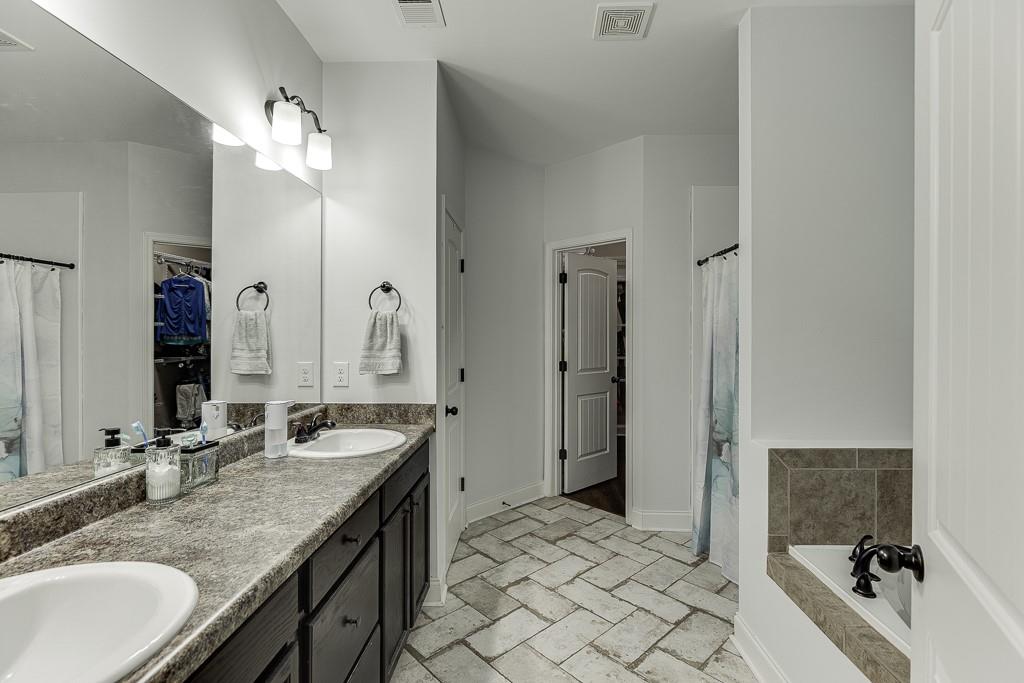 2858 Shadowstone Way Winder, GA 30680 - Photo 35 of 52 a bathroom with a granite countertop sink double vanity and a mirror