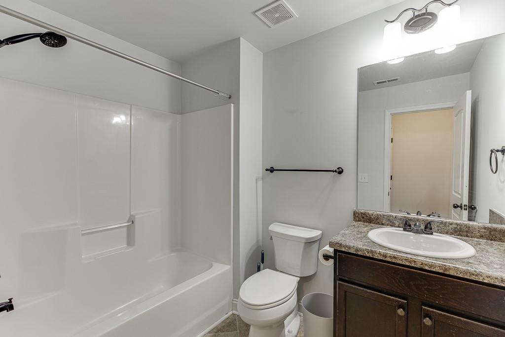 2858 Shadowstone Way Winder, GA 30680 - Photo 42 of 52 a bathroom with a granite countertop sink toilet and shower