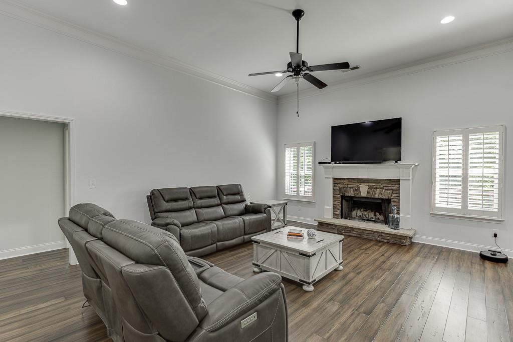 2858 Shadowstone Way Winder, GA 30680 - Photo 8 of 52 a living room with furniture a fireplace and a flat screen tv