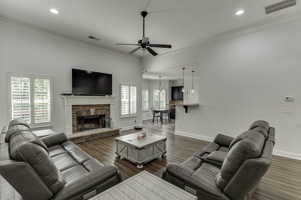 2858 Shadowstone Way Winder, GA 30680 - Photo 10 of 52 a living room with furniture a fireplace and a flat screen tv
