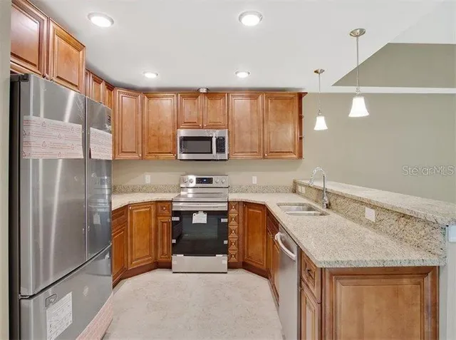 a kitchen with a sink a microwave a refrigerator and cabinets