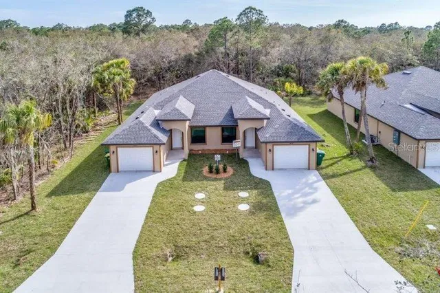 a aerial view of a house next to a big yard