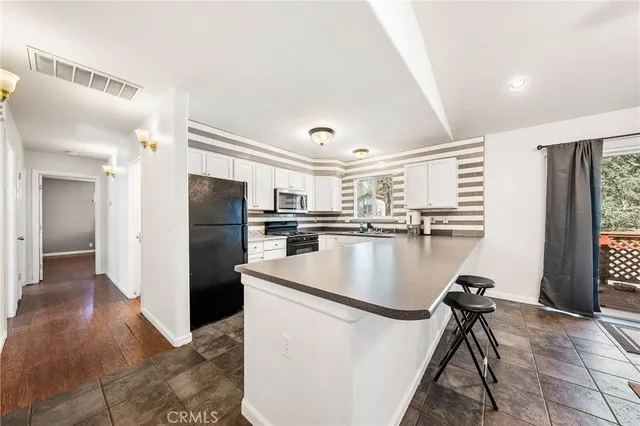 a kitchen with refrigerator and chairs