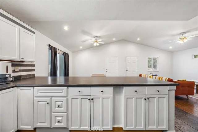 a kitchen with granite countertop a sink cabinets and stainless steel appliances