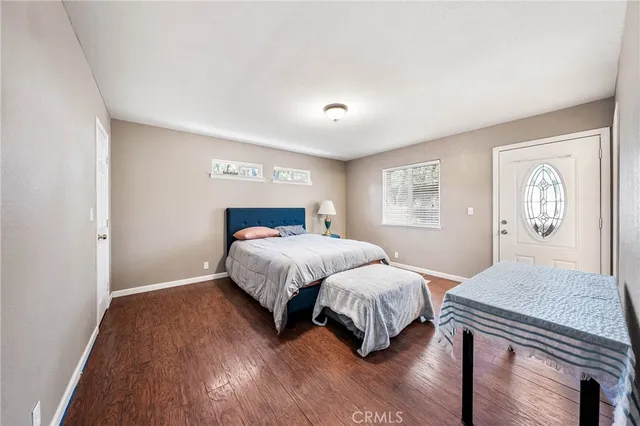 a spacious bedroom with a bed and wooden floor