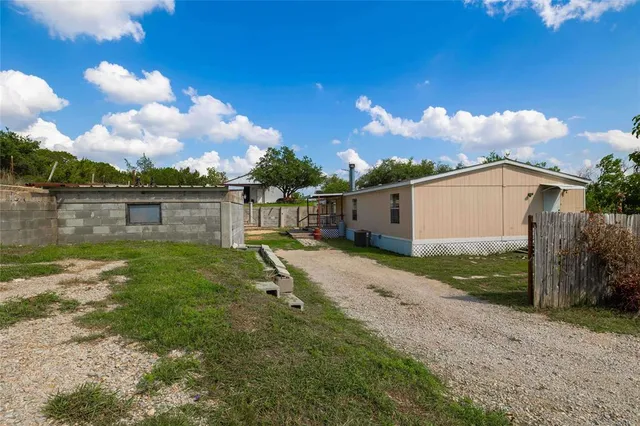 a backyard of a house with table and chairs