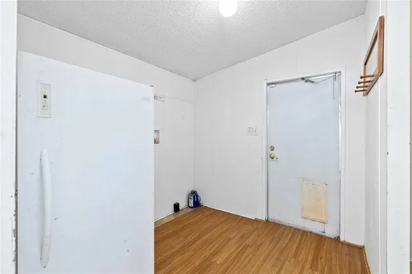 an empty room with chandelier fan and windows