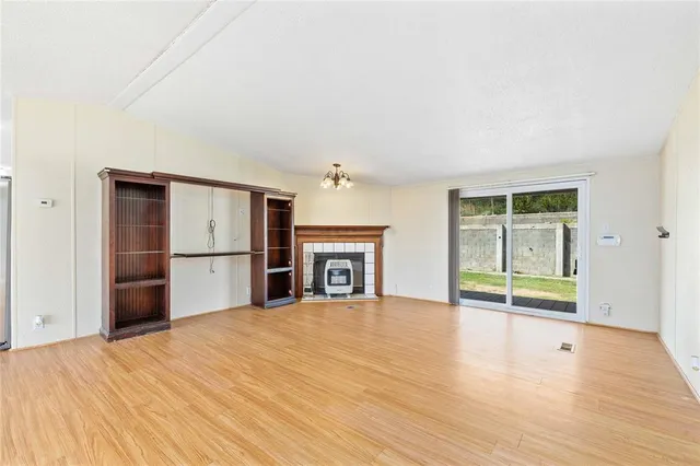 a view of empty room with wooden floor and fireplace