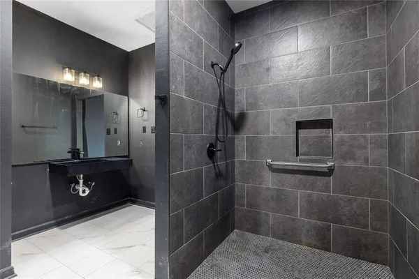 a bathroom with a sink a toilet a shower and a mirror