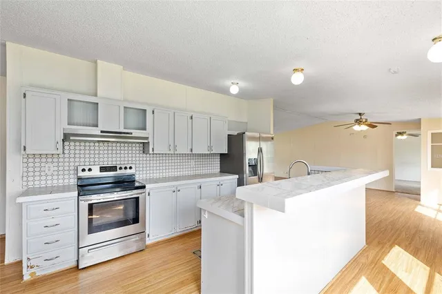 a kitchen with granite countertop a sink stainless steel appliances and cabinets