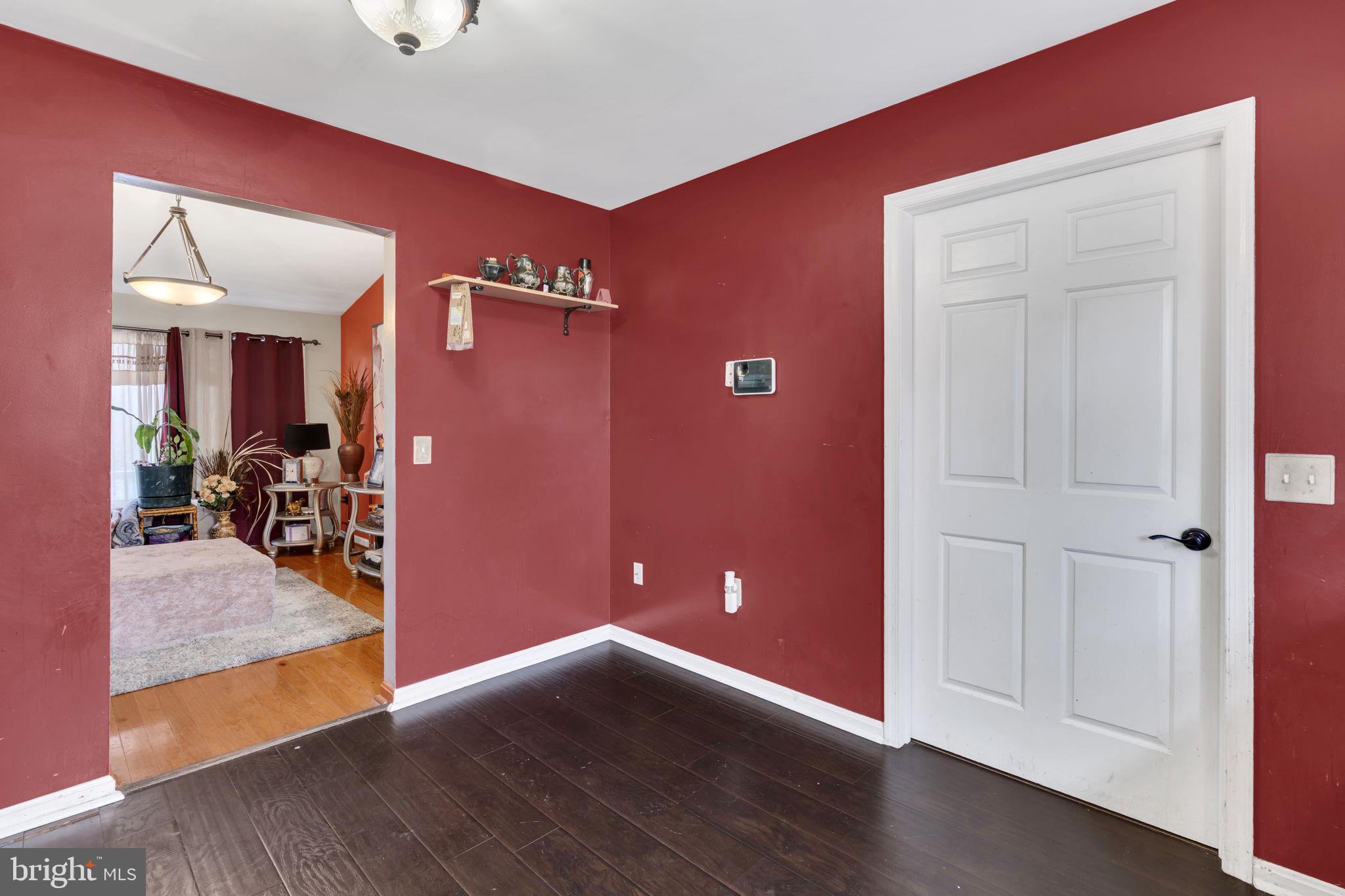 9104 Trumps Hill Road Upper Marlboro, MD 20772 - Photo 11 of 25 an empty room with wooden floor and way to kitchen