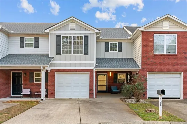 a front view of a house with yard and parking
