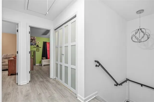 a view of a hallway with wooden floor and stairs
