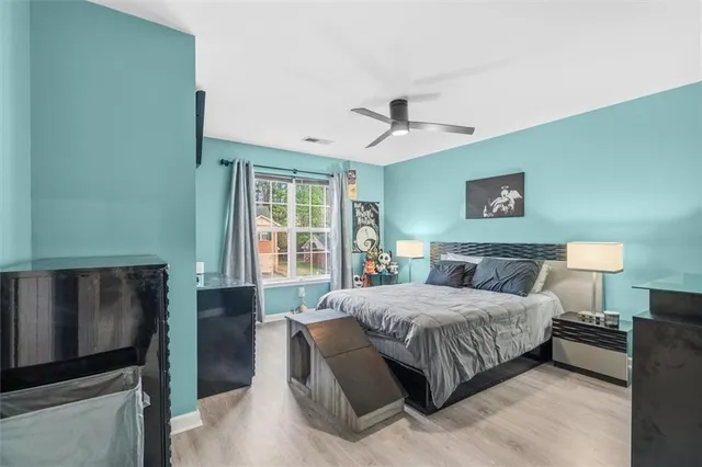 a bedroom with a large bed and a chandelier