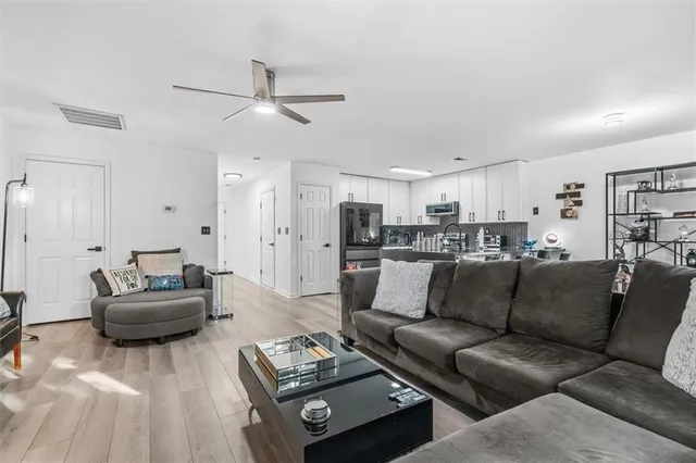 a living room with furniture and a view of kitchen