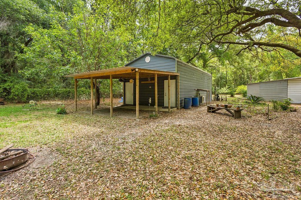 8938 Pioneer Road Holt, FL 32564 - Photo 31 of 44 a backyard of a house with table and chairs