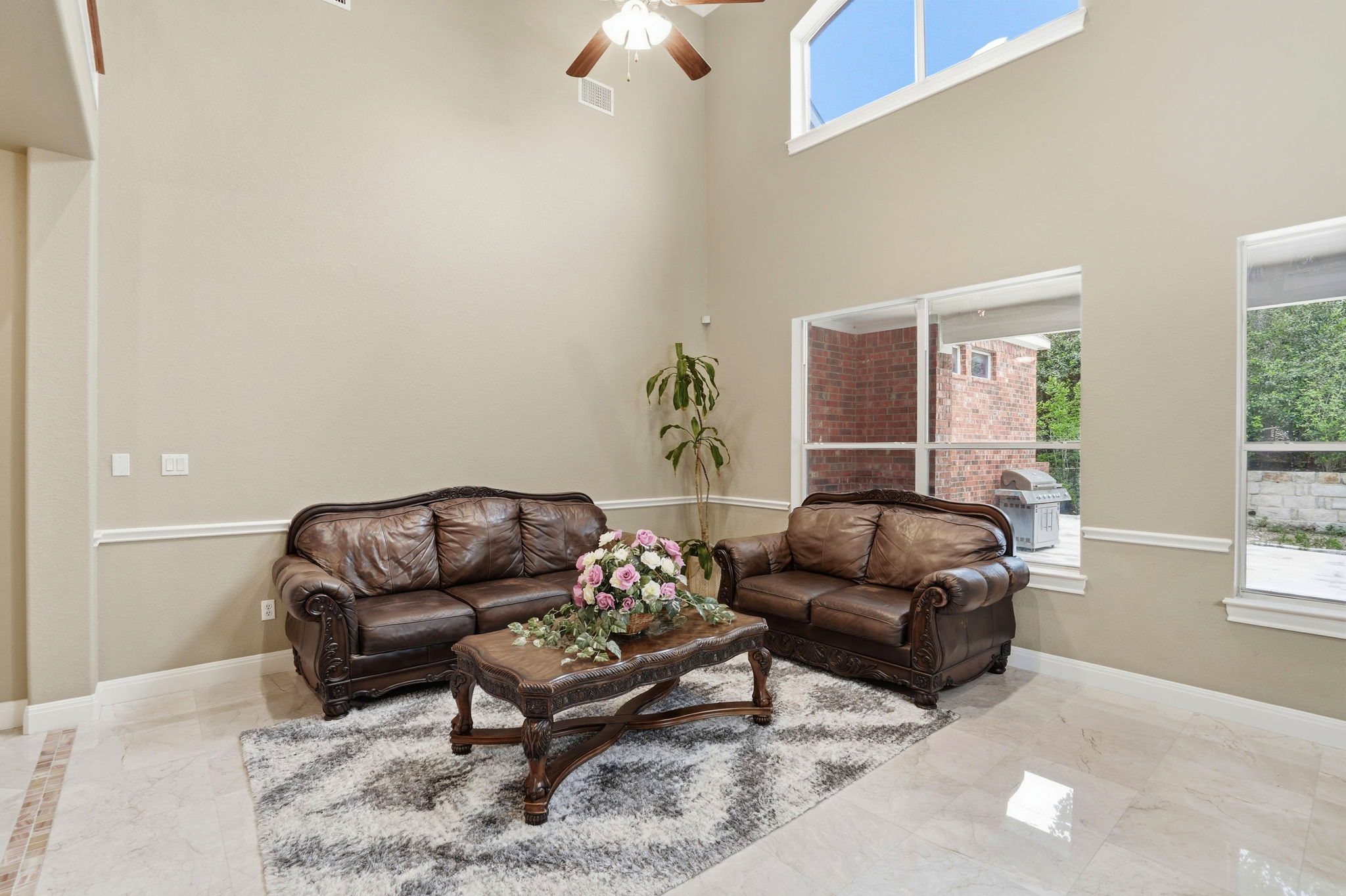222 Vailco Lane Austin, TX 78738 - Photo 10 of 39 Double-height living area featuring high ceilings, a ceiling fan, and extensive window treatments