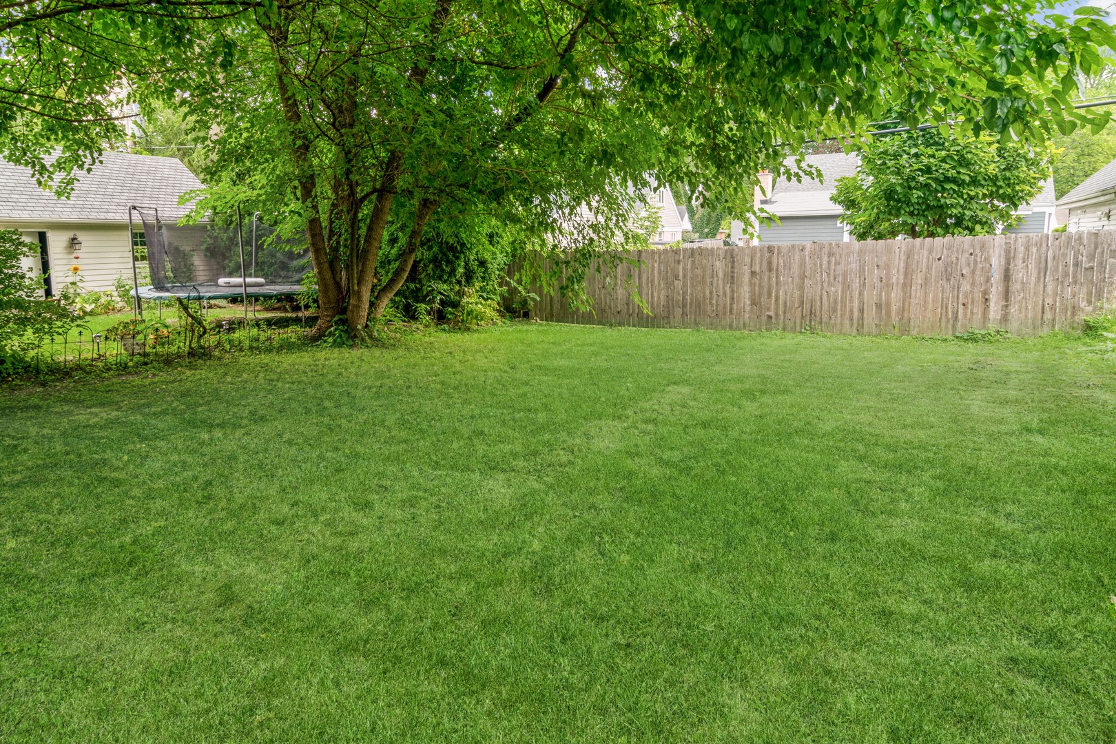 609 North County Line Road Hinsdale, IL 60521 - Photo 12 of 12 a view of a backyard with large trees and wooden fence
